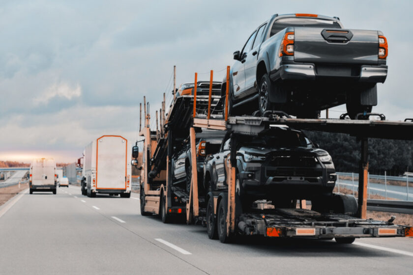New car delivery and shipping. Car transporter trailer loaded with many new cars for the customers.